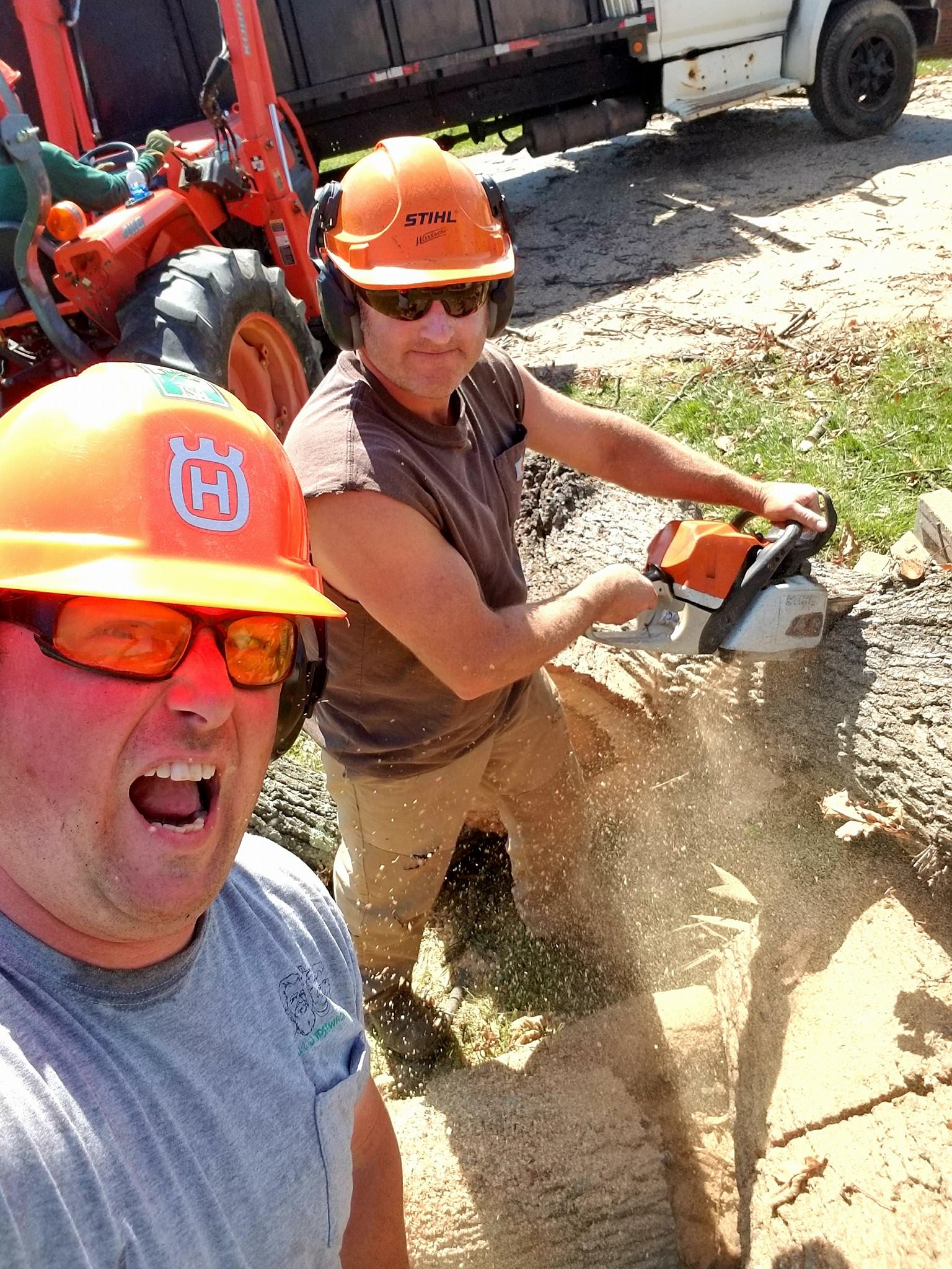 J&J Treewackers arborists cutting a felled trunk on a customer property